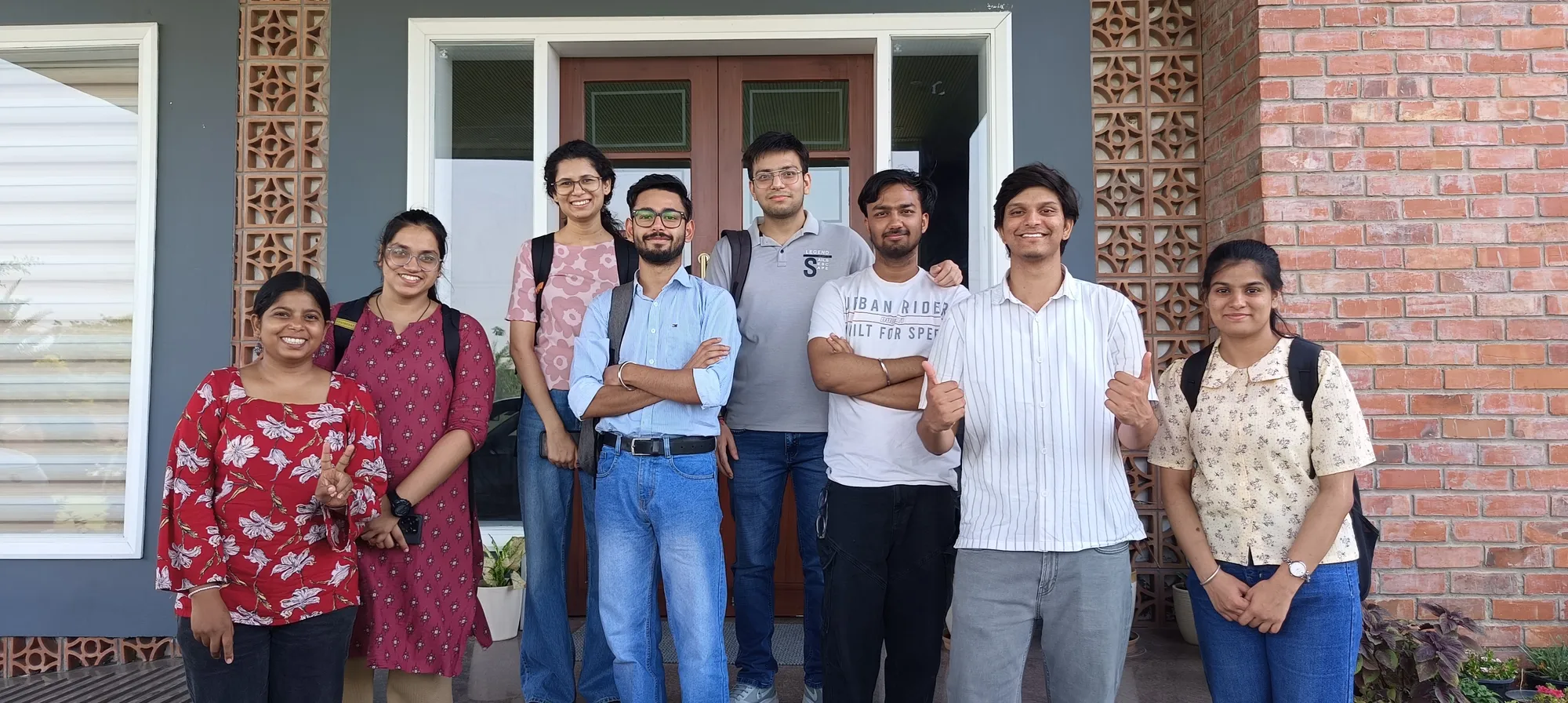 A group of eight people standing together outside a building, in a photo shared by the NIT Jalandhar team.